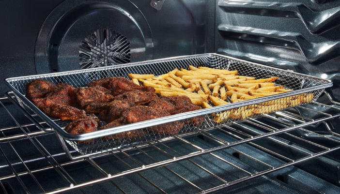 Dressed wings and french fries in a basket inside a range.