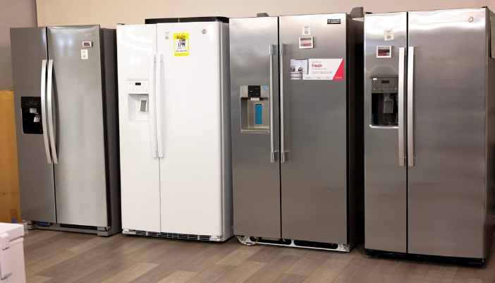 An appliance showroom of a line of refrigerators. 