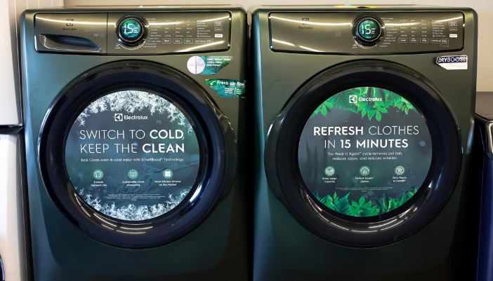 Two washer/dryers side-by-side in an appliance showroom.