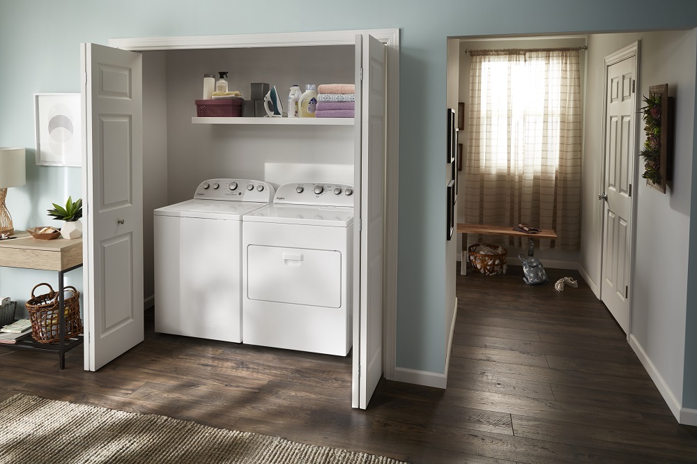 whirlpool WTW5005KW top load washer and matching dryer in a laundry closet