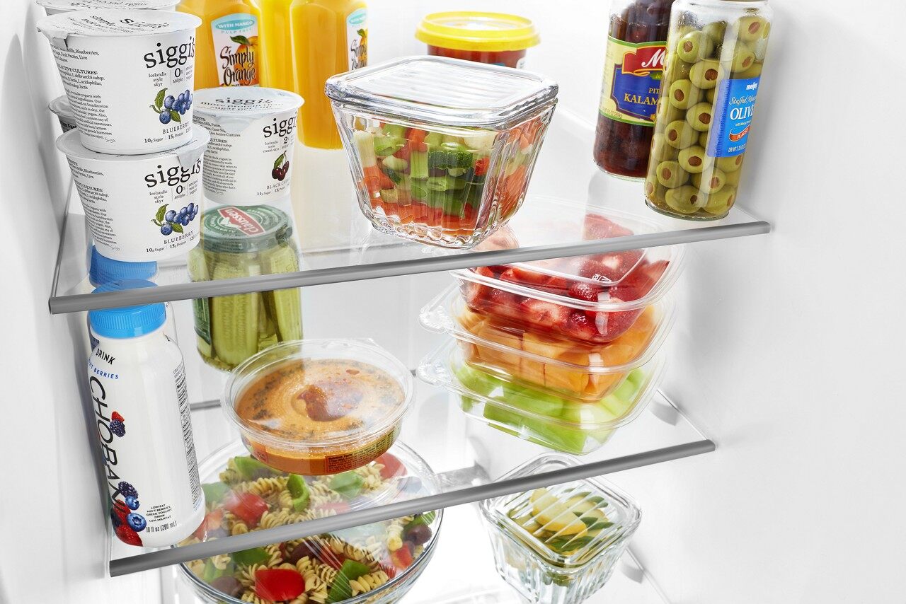 An assortment of fresh produce organized on Whirlpool WRS325SDHZ shelves 