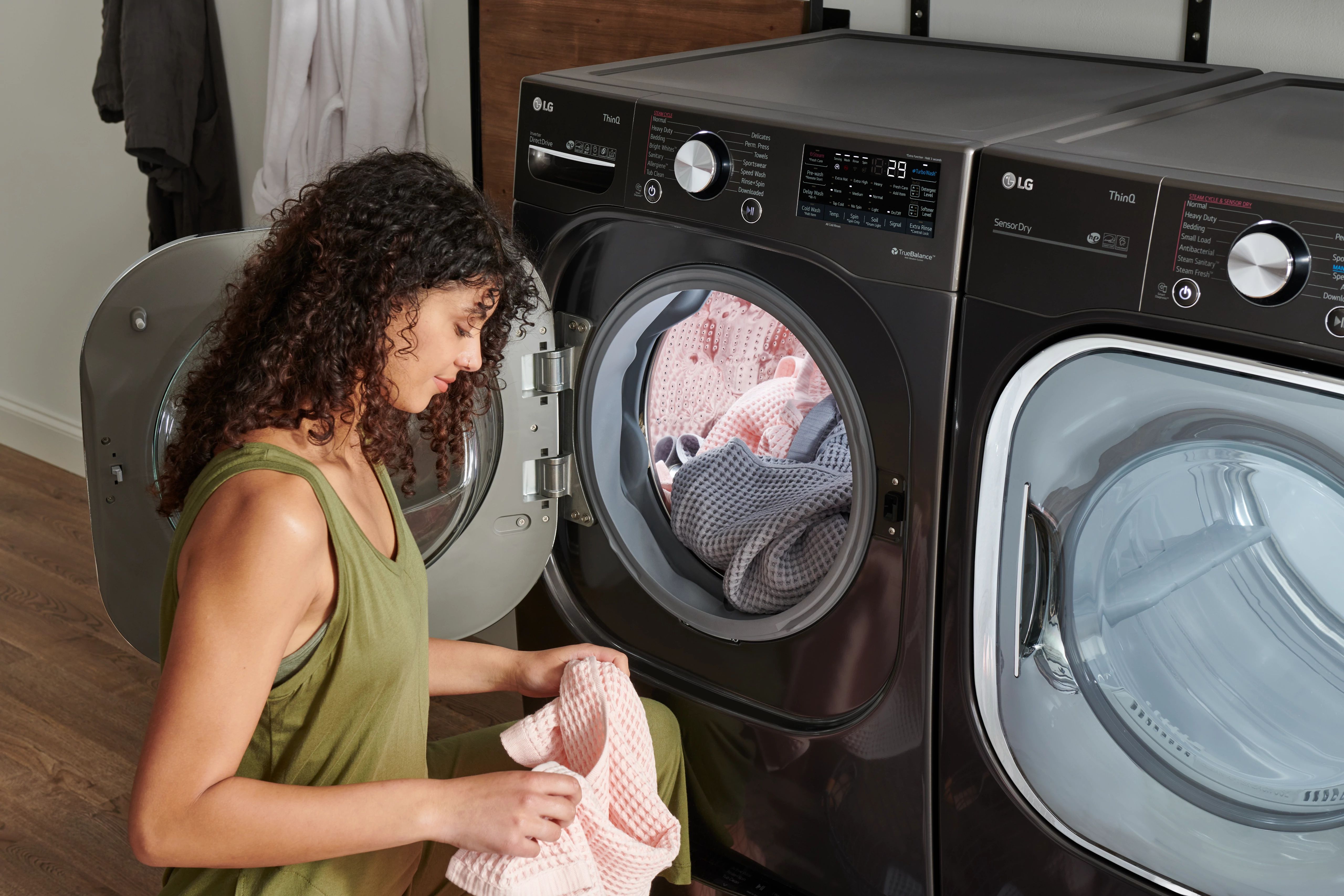 Young woman unloads clothes from LG front load washer