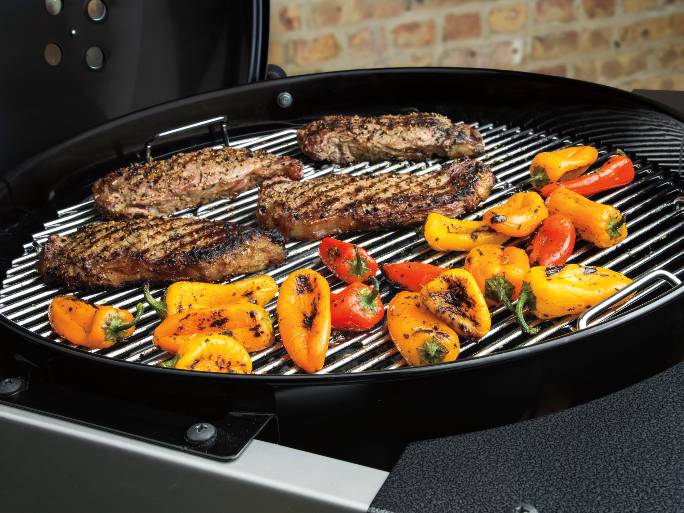 Peppers and steaks cooking on Weber 1501001 charcoal grill