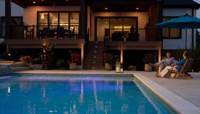 An outdoor patio at night with a couple sitting together.