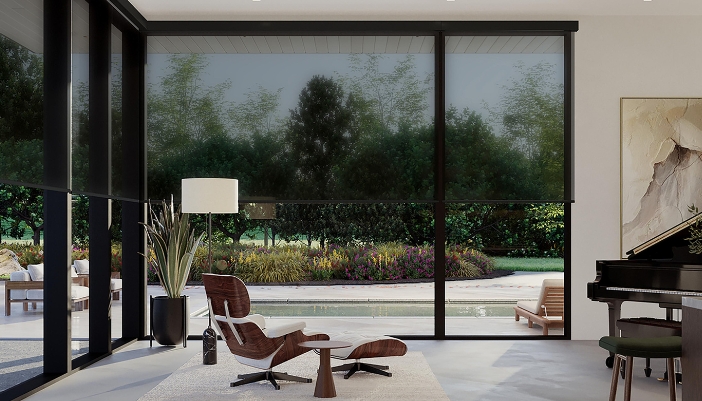 A room in a home with dark or black motorized shades that are down.
