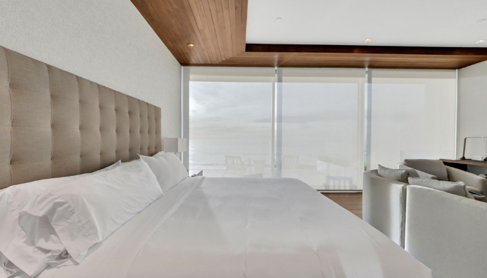 A modern bedroom with all white accents and modern shades.