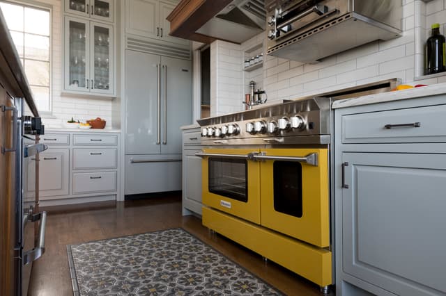 View of a luxury kitchen with a yellow BlueStar range and refrigerator