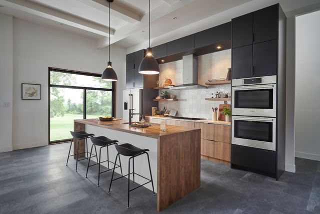 Front view of a modern kitchen with a Bosch double wall oven and refrigerator