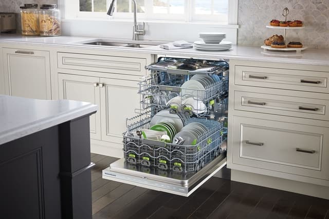 Front view of an opened Cove dishwasher in a modern kitchen Front view of an opened Cove dishwasher in a modern kitchen