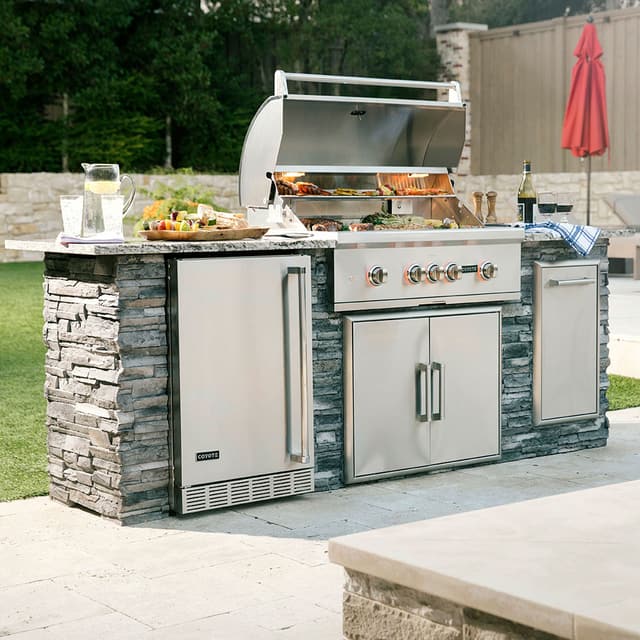 Credit: Coyote Front view of an outdoor kitchen with an opened built in grill