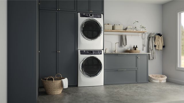 Stacked white Electrolux laundry appliances in a modern laundry room