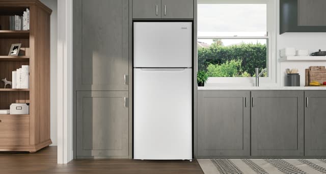 Front view of a Frigidaire top freezer refrigerator in a casual kitchen