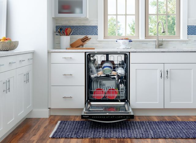 Front view of a modern kitchen with an opened Frigidaire dishwasher