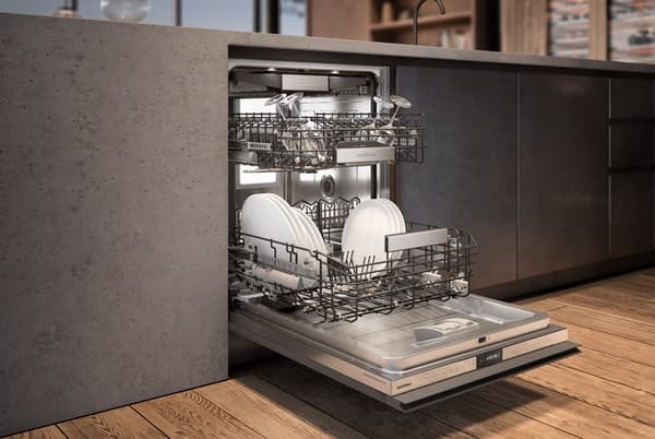 Front view of a luxury kitchen with a panel ready Gaggenau dishwasher opened with the drawers pulled out