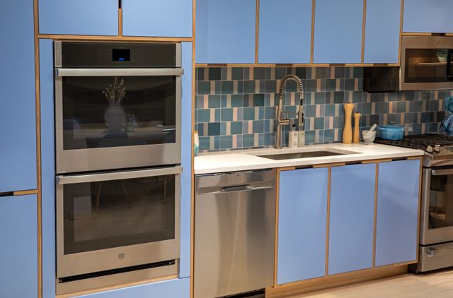 Front view of a GE double wall oven in a blue kitchen