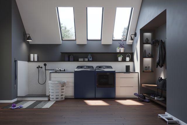 Front view of a modern laundry room with a blue GE top load washer and dryer