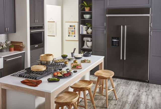Front view of a modern kitchen with a black KitchenAid 48 inch refrigerator