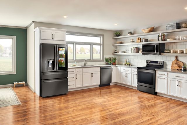 Front view of a modern kitchen with a black LG kitchen appliance package