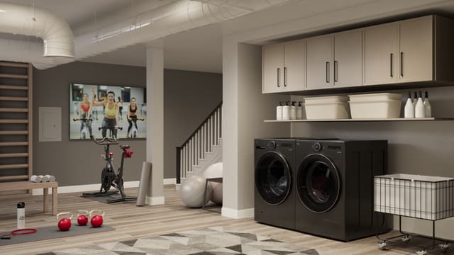 Front view of a finished basement with some exercise equipment and an LG washer and dryer