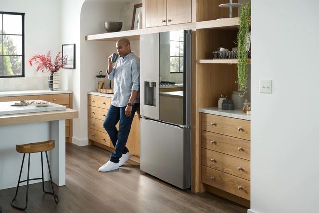 Front view of a man standing next to his LG refrigerator