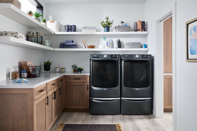 Front view of a modern laundry room with a black Maytag washer and dryer
