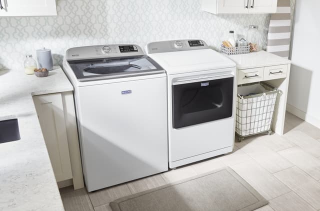 Front view of a Maytag washer and dryer in a casual laundry room Front view of a Maytag washer and dryer in a casual laundry room