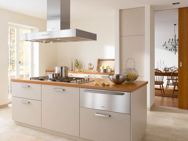 Credit: Miele Front view of a modern kitchen with a Miele gas cooktop and rangehood pair