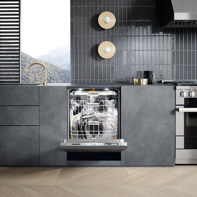 Front view of a modern kitchen with an opened Miele dishwasher