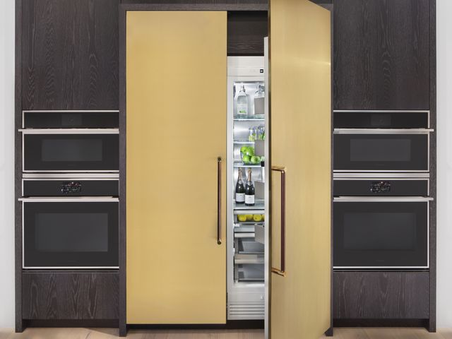 Front view of a modern kitchen with an opened panel-ready Monogram refrigerator