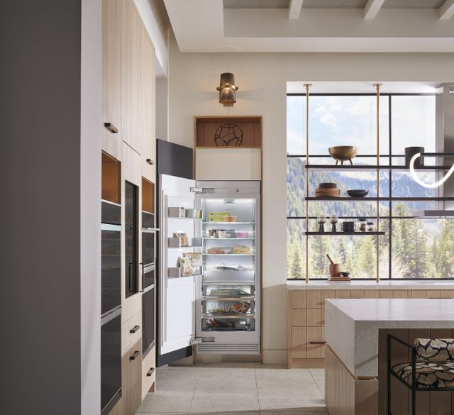 Front view of a modern kitchen with an opened Monogram column refrigerator