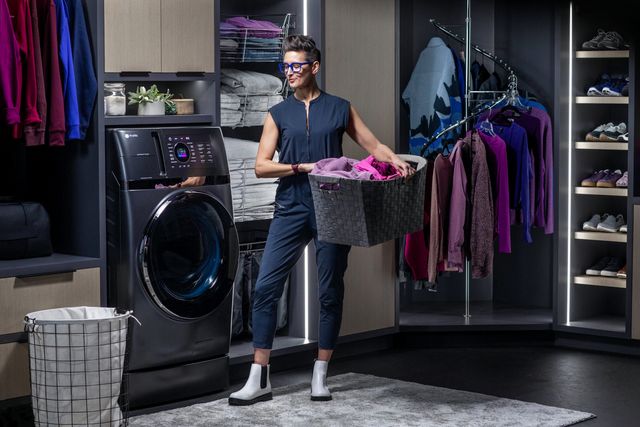 Front view of a luxury laundry room and a woman doing laundry with her washer and dryer combo
