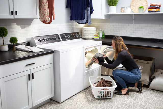Credit: Speed Queen Front view of a woman pulling clothes out of her Speed Queen dryer