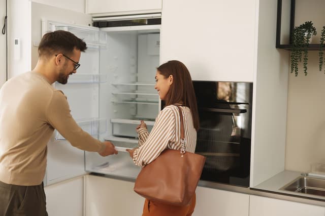 View of a couple appliance shopping in a showroom View of a couple appliance shopping in a showroom