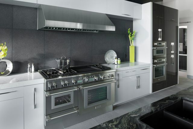 Credit: Thermador Front view of a modern kitchen with stainless steel Thermador appliances including a range, a range hood, and two wall ovens