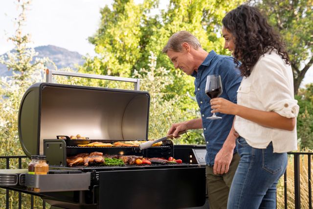 Credit: Traeger Front view of a man and woman grilling together on a Traeger Ironwood