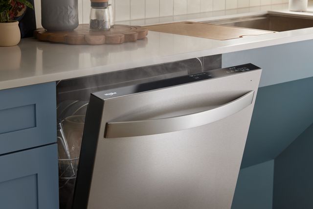 Front view of a modern kitchen with a slightly opened dishwasher