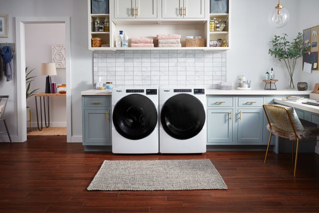Credit: Whirlpool Front view of a modern laundry room with a white Whirlpool front load washer and dryer