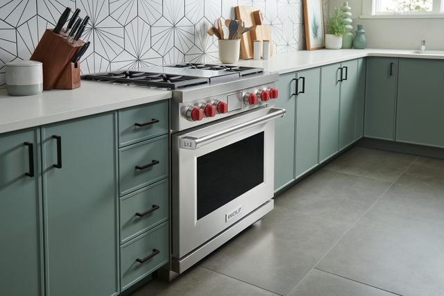 Credit: Wolf Front view of a modern kitchen with a Wolf range with iconic red knobs.