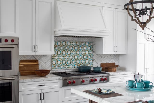 Close view of a modern kitchen with a Wolf rangetop and double wall oven