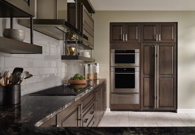 Front view of a modern kitchen with a Wolf cooktop and double wall oven