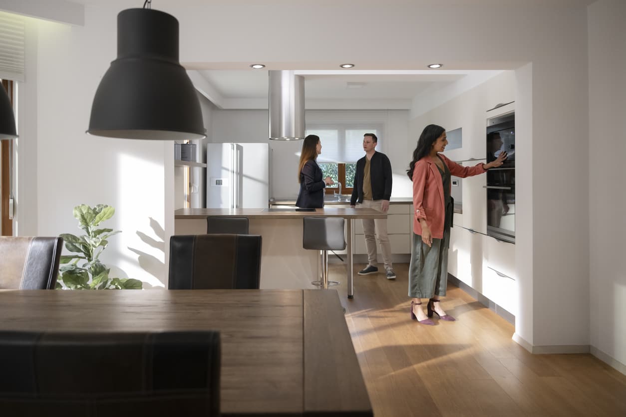 Credit: iStock Front view of a new kitchen build with new appliances and a few people checking them out