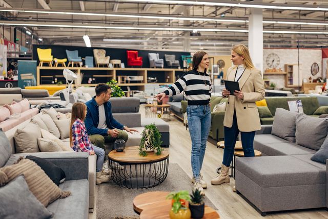 Front view of a family shopping for a new sofa in a furniture store