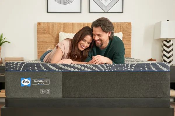 Credit: Sealy Front view of a couple relaxing on a Sealy queen mattress