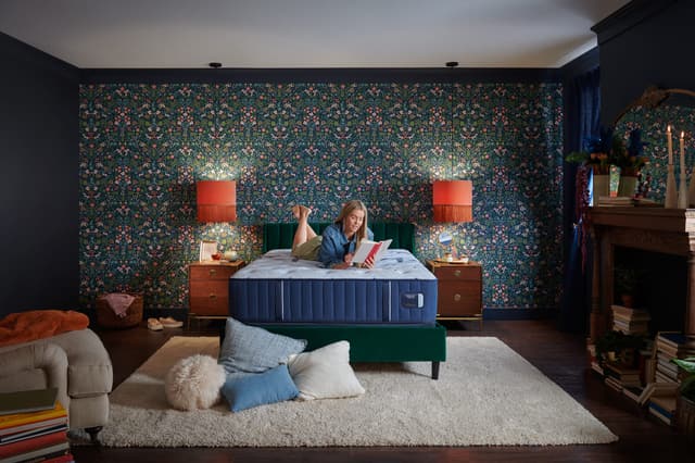 Front view of a modern bedroom with a woman reading on her Stearns and Foster mattress Front view of a modern bedroom with a woman reading on her Stearns and Foster mattress