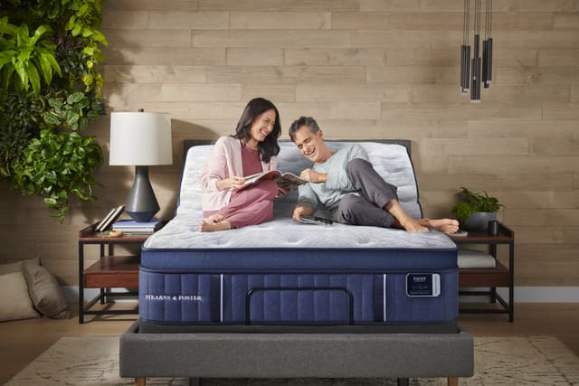 Front view of a couple smiling and lounging on a stearns and foster mattress Front view of a couple smiling and lounging on a stearns and foster mattress