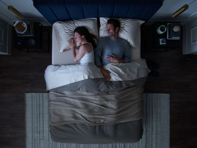 Credit: Tempur-Pedic Top view of a man and woman sleeping on their back and side on a TempurPedic queen mattress