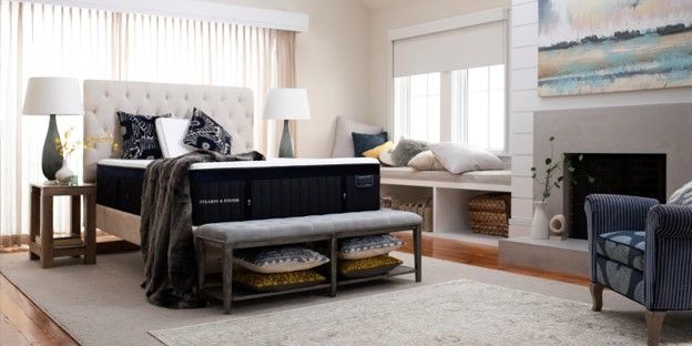 Furnished bedroom with a Stearns & Foster mattress on an upholstered bed