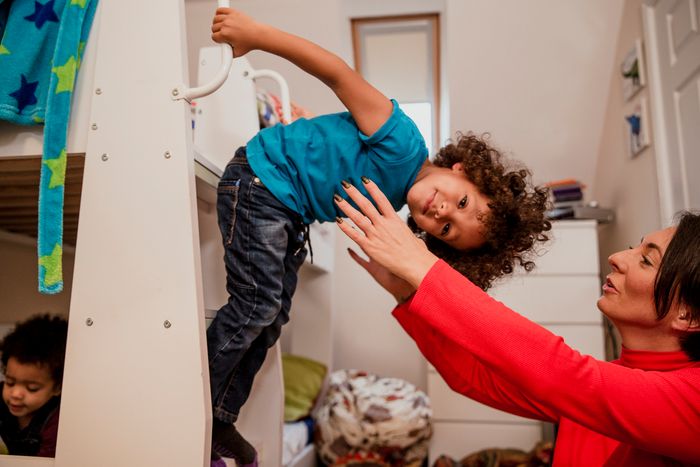 Young boy on bunk bed stairs playing with his mother