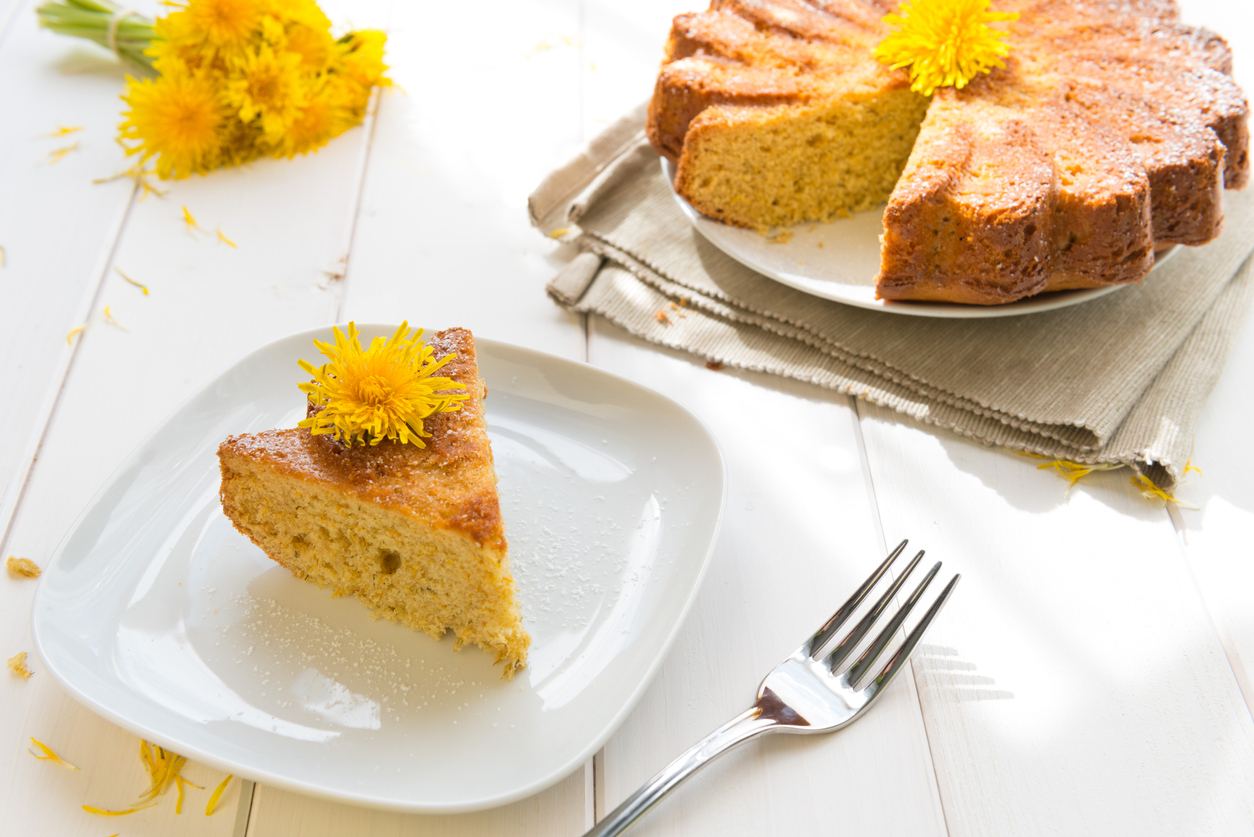 a sliced dandelion blossom cake with a flower on top