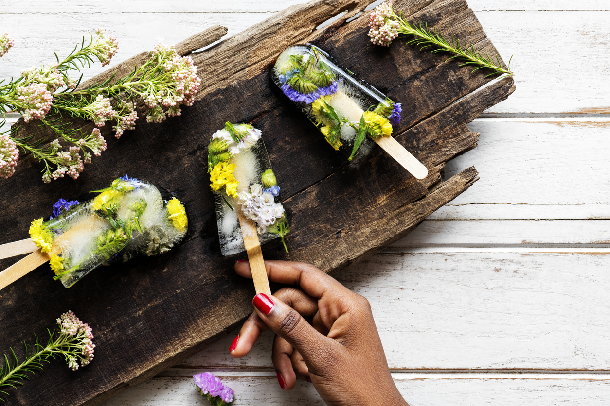 a tray of clear ice pops with assorted flowers inside them